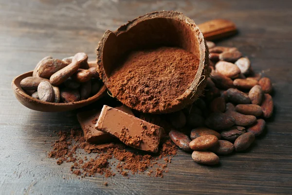 Cuenco con cacao en polvo y chocolate sobre fondo de madera, primer plano — Foto de Stock