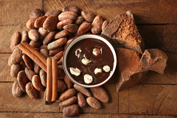 Aromás kakaó termés, finom csokoládé a fából készült háttér, közelről — Stock Fotó