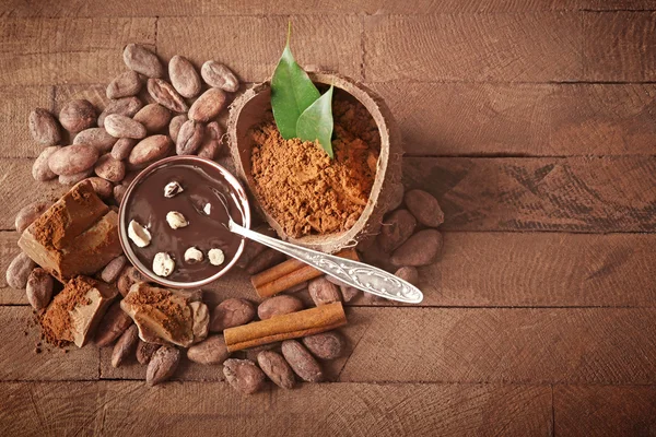 Aromatische cacao oogst met lekkere chocolade op houten achtergrond, close-up — Stockfoto