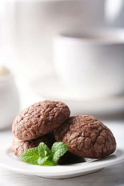 Шоколадное печенье в тарелке с мятой, крупным планом — стоковое фото