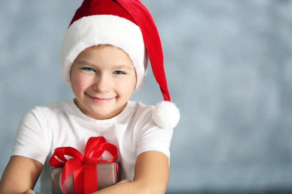 Хлопчик у капелюсі Санта з подарунковою коробкою — стокове фото