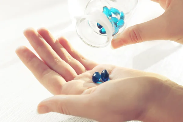 Blue pills in female hands — Stock Photo, Image