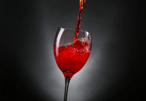 Wine pouring in glass on grey background — Stock Photo, Image