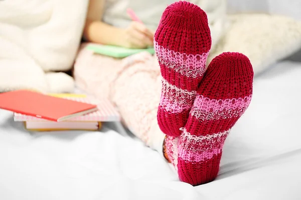 Vrouwelijke voeten in wollen maroon sokken — Stockfoto