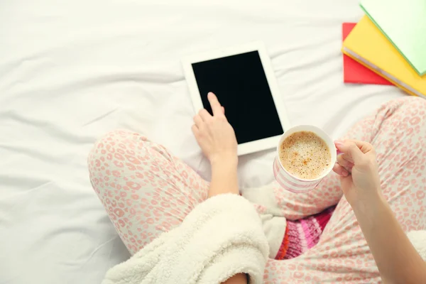 Женщина в пижаме с помощью планшета — стоковое фото