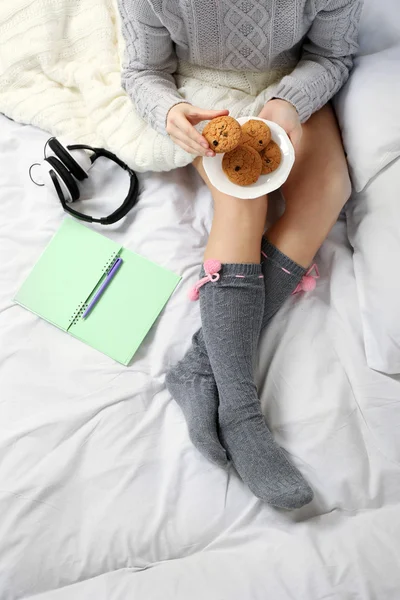Frau mit Kopfhörer isst Kekse — Stockfoto
