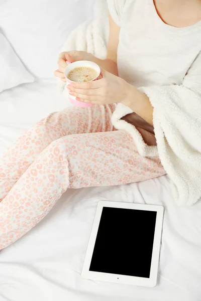 Vrouw in pyjama's met Tablet PC — Stockfoto