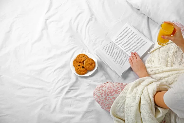 Frau im Schlafanzug liest ein Buch — Stockfoto