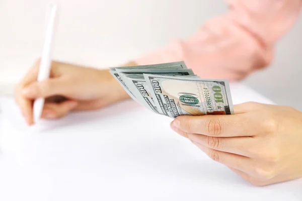 Mão segurando notas de dólar no fundo branco — Fotografia de Stock