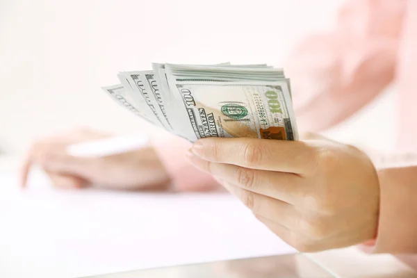 Mão segurando notas de dólar no fundo branco — Fotografia de Stock