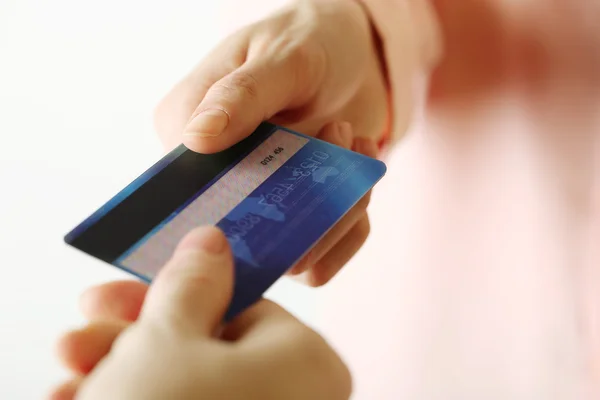 Manos sosteniendo tarjeta de crédito azul sobre fondo blanco —  Fotos de Stock