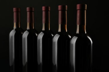 Siyah arka plan üzerine üst üste şişe şarap, yakın çekim