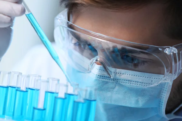 Man in laboratory checking test tubes — Stock Photo, Image