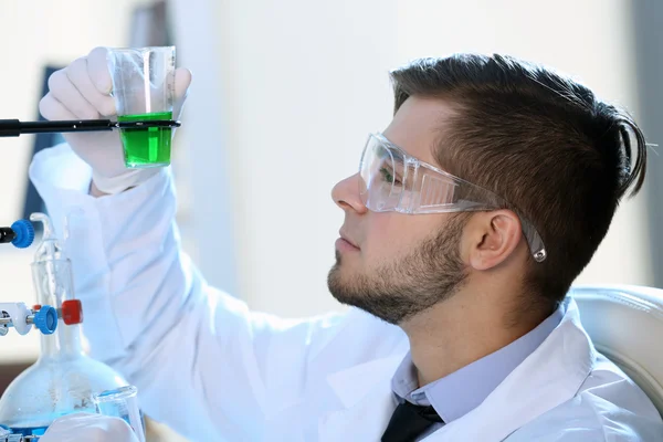 Hombre en laboratorio comprobando tubos de ensayo — Foto de Stock