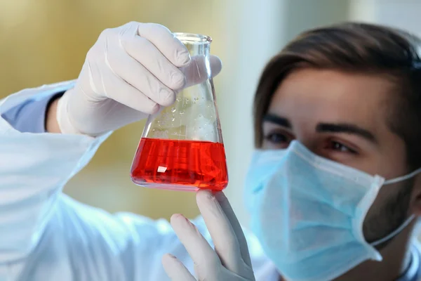 Mann im Labor kontrolliert Reagenzgläser — Stockfoto