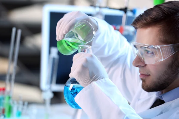 Mann im Labor kontrolliert Reagenzgläser — Stockfoto