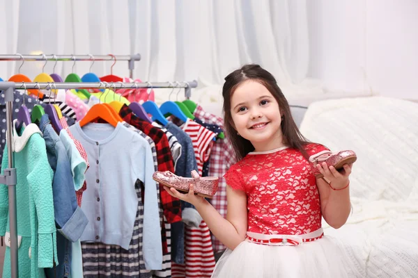 Little girl holding shoes in her hands — Stock Photo, Image