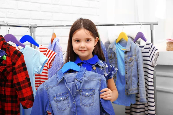 Kleines Mädchen probiert ein neues Jeanshemd an — Stockfoto