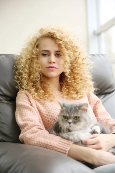 Жінка і кіт на дивані в кімнаті — стокове фото