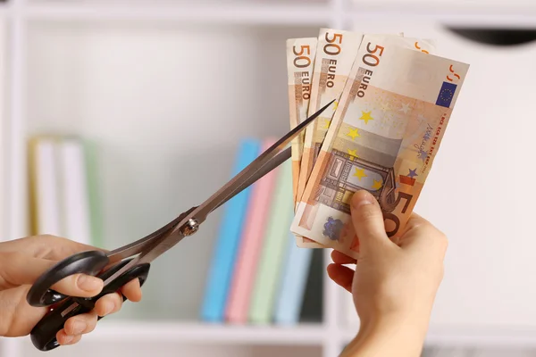 Mãos com tesoura cortando Euro — Fotografia de Stock