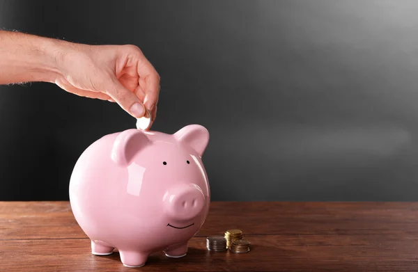 El hombre poniendo dinero en la caja de dinero —  Fotos de Stock