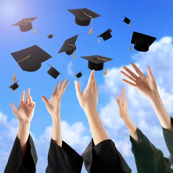 Graduados manos lanzando sombreros de graduación — Foto de Stock