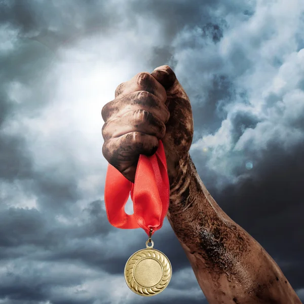 Golden medal in dirty hand — Stock Photo, Image