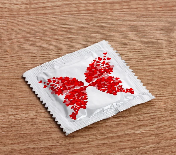 Condom on wooden table — Stock Photo, Image