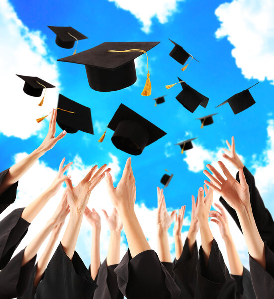 Graduates hands throwing graduation hats