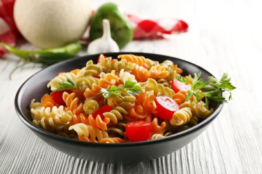 Lezzetli makarna yemek hizmet gri ahşap masa üzerinde siyah kase