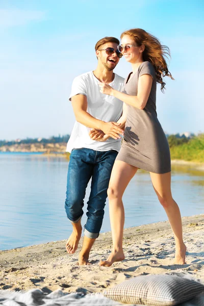 Pareja joven en la orilla del río —  Fotos de Stock