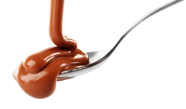 Melted milky brown chocolate pouring from a spoon, isolated on white — Stock Photo, Image