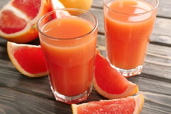 Glass of grapefruit juice and fresh fruits on wooden background — Stock Photo, Image