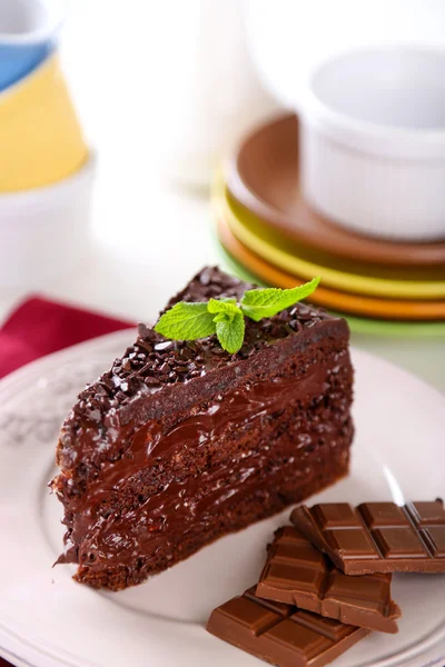 Chocolate cake with chocolate cream on plate, on light background — Stock Photo, Image