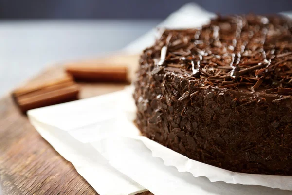 Gâteau au chocolat savoureux sur fond en bois couleur — Photo