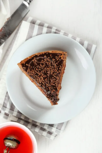 Torta affettata al cioccolato su piatto, su fondo tavolo in legno — Foto Stock