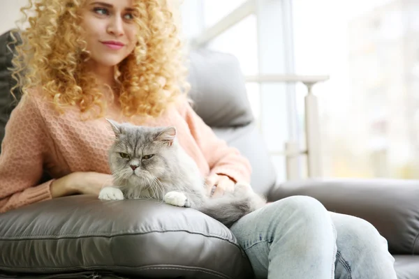 Ung kvinna och katt på soffa — Stockfoto
