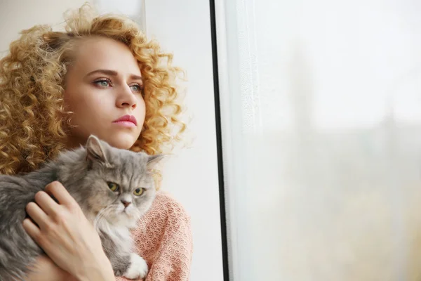 Young woman and cat on windowsill