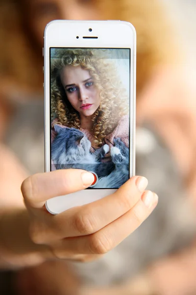 Młoda kobieta trzyma smartfon — Zdjęcie stockowe