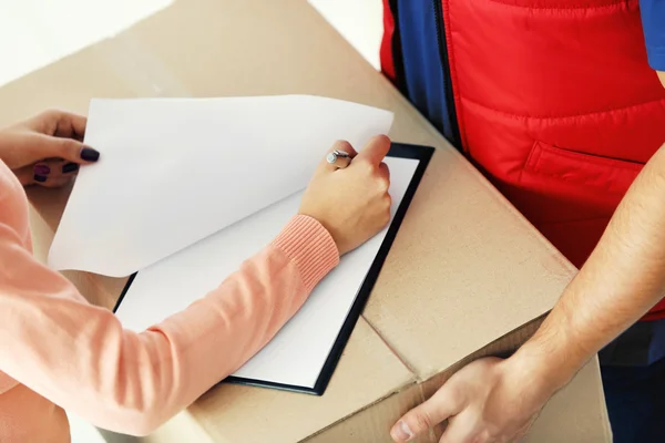 Woman signing delivery receipt — Stock Photo, Image