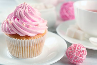 Lezzetli pembe cupcake fincan çay ve süslemeleri, closeup ile