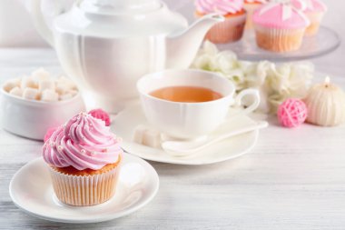 Işık arka plan üzerinde çay bardağı ile lezzetli pembe topkek