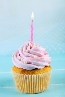 Açık renkli mum ile dekore edilmiş lezzetli pembe topkek