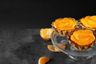 Karanlık metal masa üzerinde taze mandalina ile kase, yakın çekim