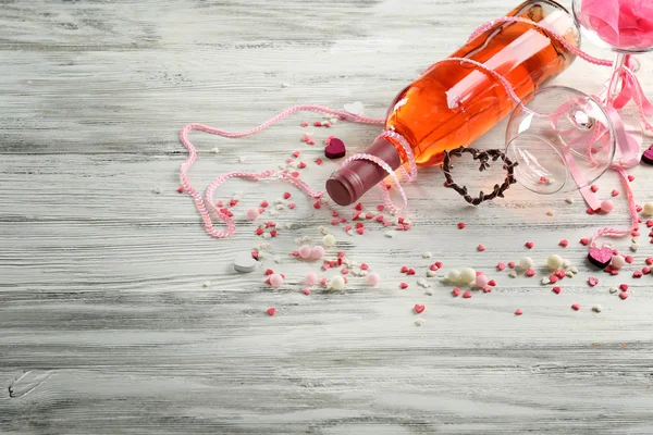 Láska koncept - víno láhev s dekoracemi na bílém pozadí dřevěná — Stock fotografie