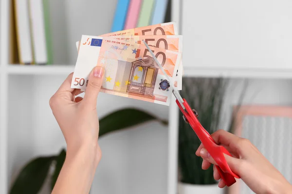 Hände mit der Schere schneiden Euro — Stockfoto