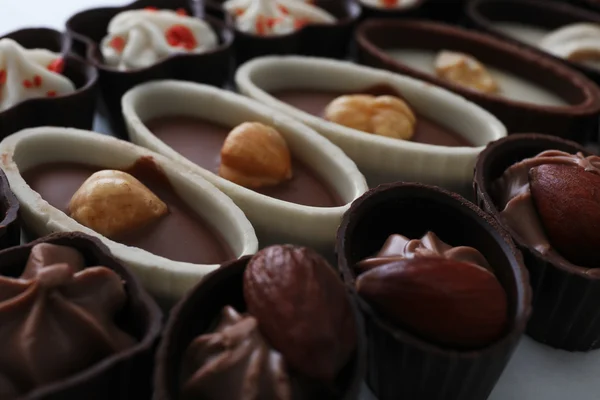 Zusammensetzung von Schokoladenbonbons auf weißem Hintergrund, Nahaufnahme — Stockfoto