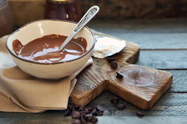 Chocolat fondu dans un bol en verre, sur fond en bois — Photo