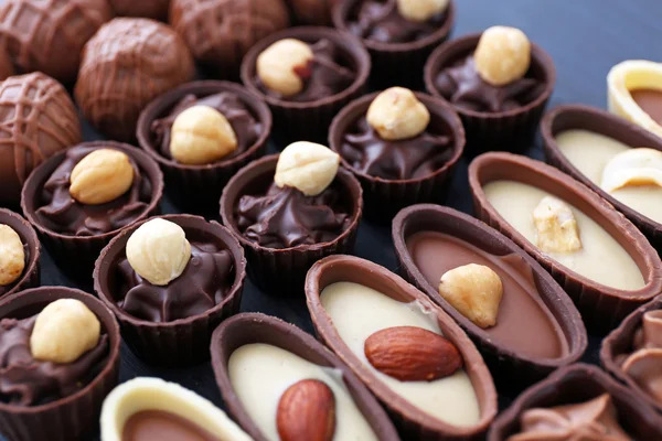 Deliciosos doces de chocolate em fundo de madeira azul, close-up — Fotografia de Stock