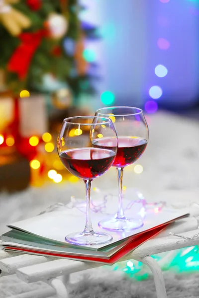 Dos copas de vino tinto sobre fondo de decoración navideña — Foto de Stock